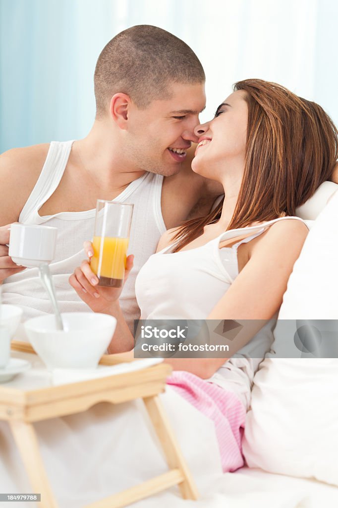 Felice giovane coppia a letto - Foto stock royalty-free di 20-24 anni