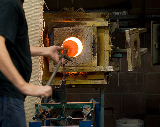 istock Glass blower working at a furnace 184980199