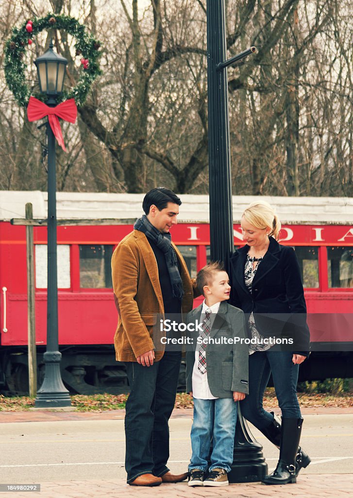 Happy Family a happy family of three standing in front of a train during christmas season.  6-7 Years Stock Photo
