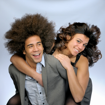 waist up shot of a smiling embracing young couple on gray background