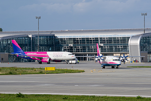 Motor Sich Antonov An-140 taxiing for takeoff from Lviv for a flight to Kyiv with WizzAir Airbus A320 on the background