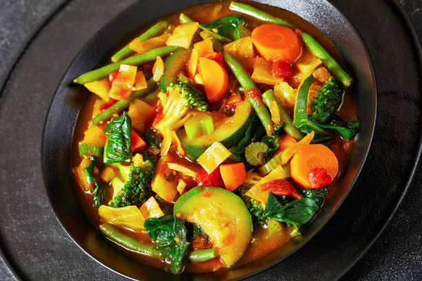 istock vegetable soup with green beans, broccoli, carrot, celery, spinach, cabbage, onion, tomatoes in black bowl 1849824129