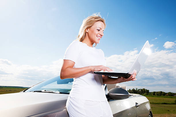 istock Young woman using her laptop against the sky and clouds. 184983178