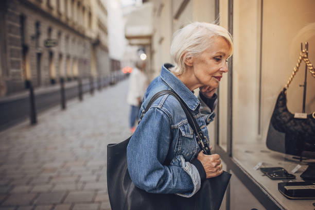 Modern woman window shopping Modern mature woman window shopping on the street of Vienna. city street consumerism window display vienna stock pictures, royalty-free photos & images