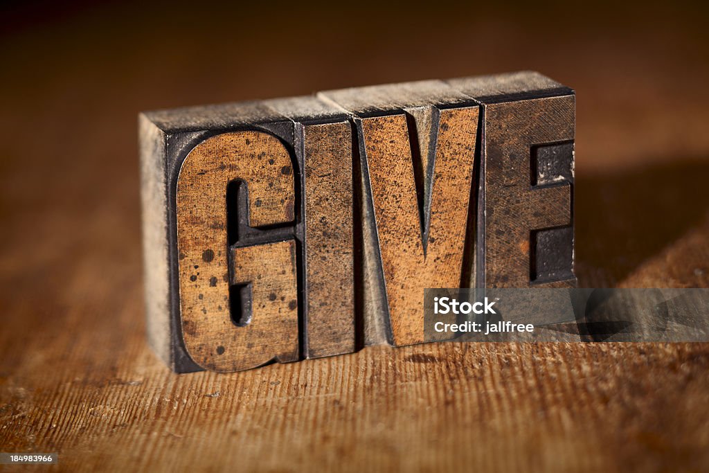 Dê por escrito em tipógrafo de madeira em fundo de madeira - Foto de stock de Caridade e assistência royalty-free