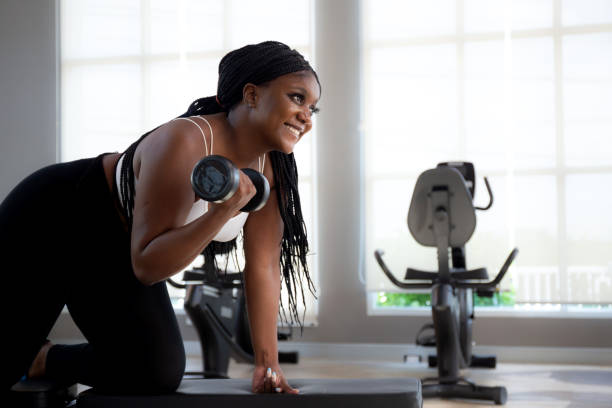 istock Young black woman training exercise or workout with lifting dumbbell for bodybuilder with strong in fitness gym, woman practicing weightlifting for strength of muscle and motivation, sport concept. 1849847682