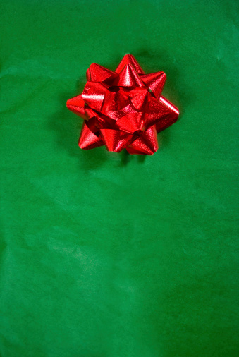 christmas gift; red bow on green wrapping paper