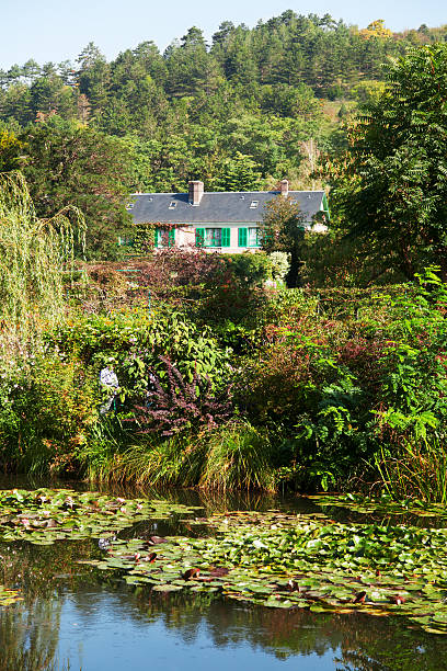 Monet's water lily pond made by Clode Monet himself - this scenery has been inspiration for a lot of his impressionistic artwork, His house painted in pink and green, his favourite colors, is seen in the background.
