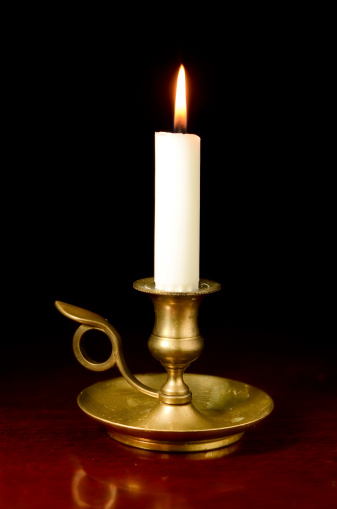 A candle in a handheld candleholder