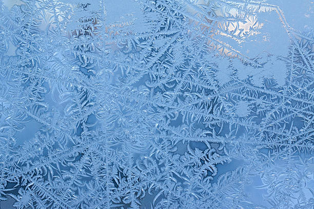 Frost pattern on a window Ice crystals on a window. ice crystal blue frozen cold stock pictures, royalty-free photos & images