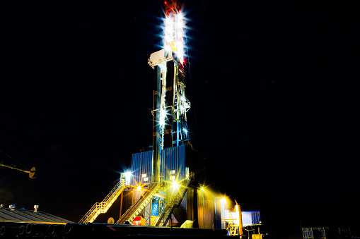 Night photo drilling rig in oil field for drilled into subsurface