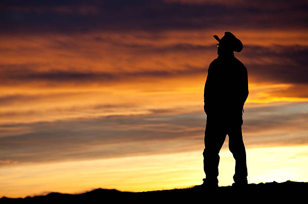 Senior man watching sunrise on a cold autumn morning in the heath cold Brunssummerheide