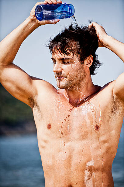 istock Young brazilian man pouring water on his head after workout 184985811