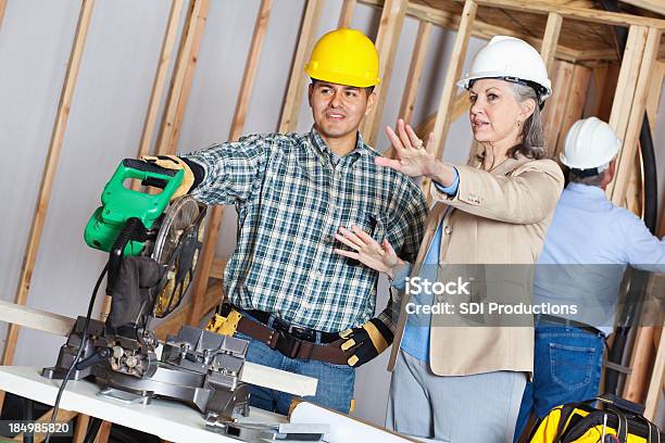 Direcções A Ser Administrada Ao Trabalhador Da Construção Civil Na Construção De Nova Casa - Fotografias de stock e mais imagens de Adulto