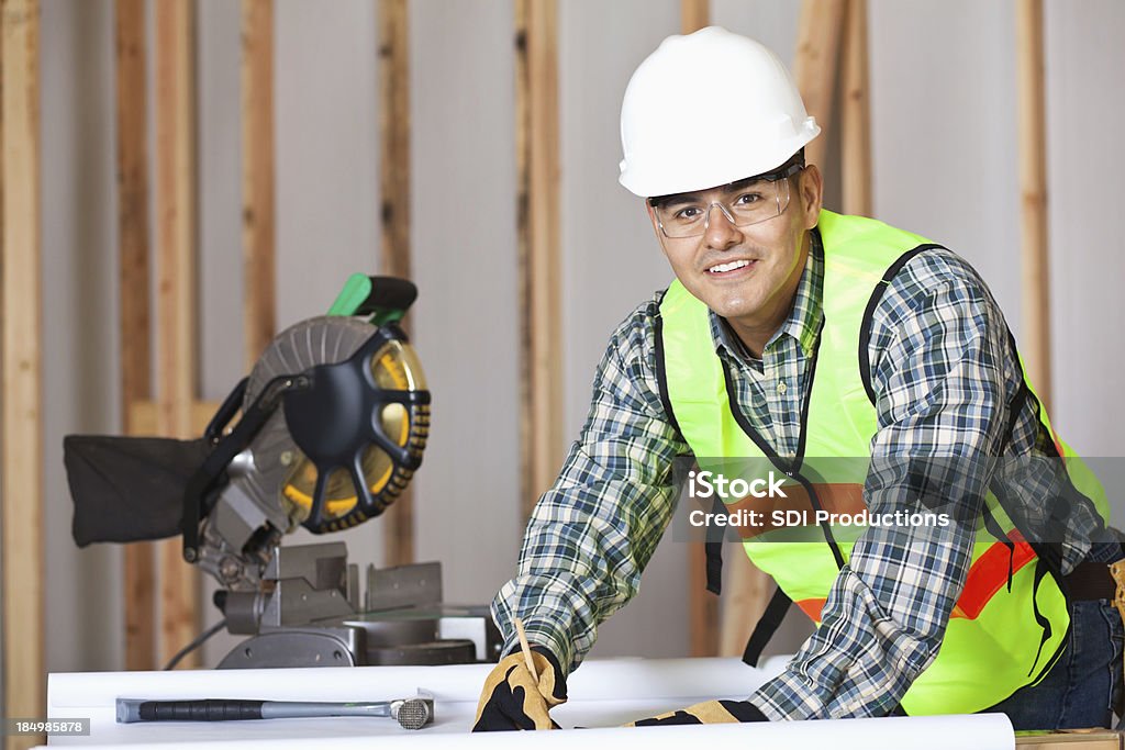 Trabajador mirando hacia arriba en solar de construcción - Foto de stock de Carpintero libre de derechos