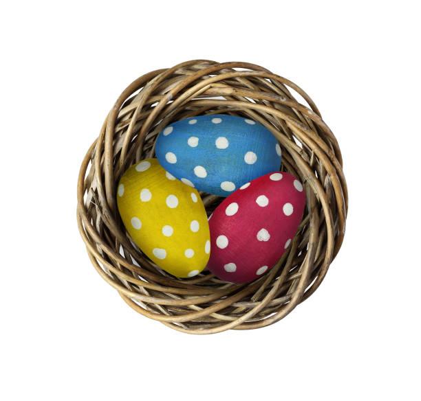 Wooden painted eggs in a twisted round nest isolated on white. Easter concept.
