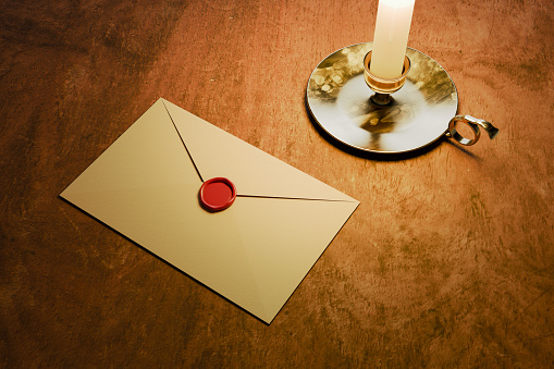 a sealed envelope next to candlelight