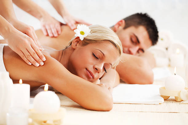 bella coppia, godendo il massaggio alla schiena. - spa treatment health spa massaging couple foto e immagini stock