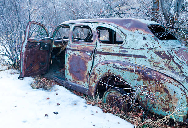 An old rusted antique car on the trails of Park City Utah. Old Car in the Snow.