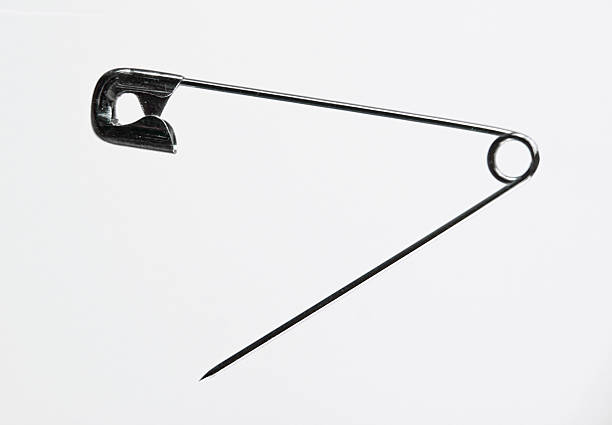 istock Open metal safety pin against a white background 184987772