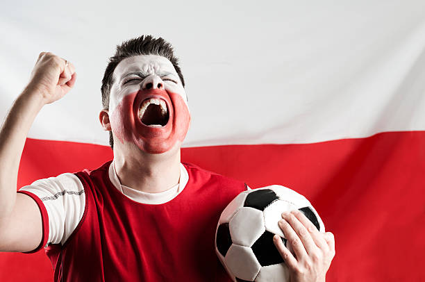 istock Man with white and red makeup on face holding soccer ball 184988525