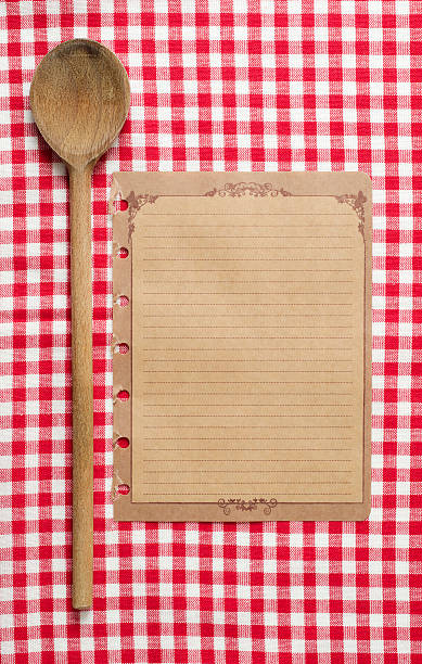 istock Wooden spoon and old paper on red tableclot 184988759