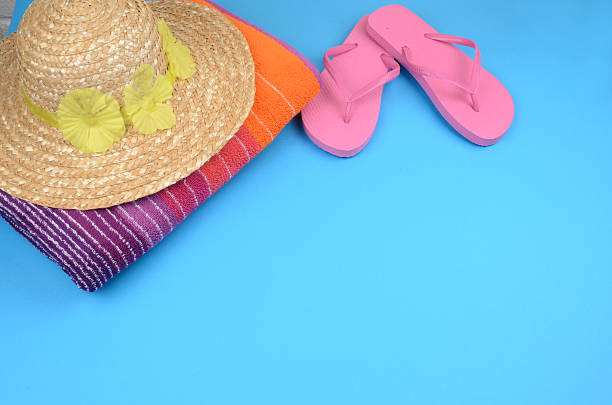 istock Beach towel with flipflops and straw sunhat 184990185
