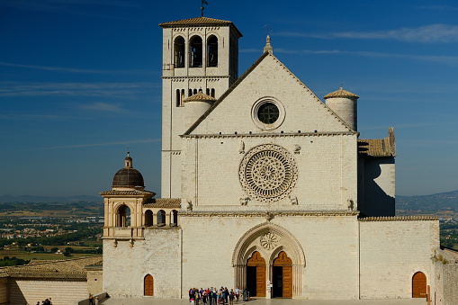 Church of San Francesco in Assisi with the stone wall. The basilica built in Gothic style houses the frescoes by Giotto and Cimabue.