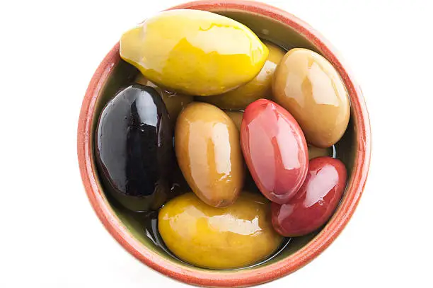 small bowl of assorted Cerignola Olives on white background from above