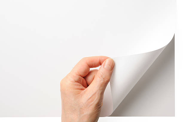 Close-up shot of opening a blank page by the hand Close-up shot of a hand turning a blank page isolated on white background with clipping path. new page stock pictures, royalty-free photos & images