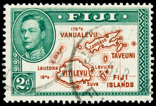 King George VI and a map of the Fiji islands on a cancelled twopence stamp from 1938. Isolated on black with excellent detail.Vintage Air Mail stamps: