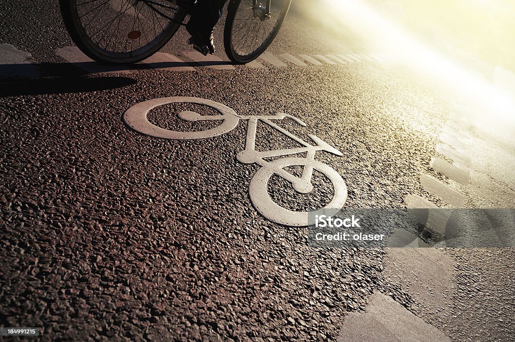 Bike lane in the evening "Bike lane, fall in Stockholm. Sign for bicycle painted on the asphalt. Dividing line, diminishing perspective. See also" Active Lifestyle Stock Photo