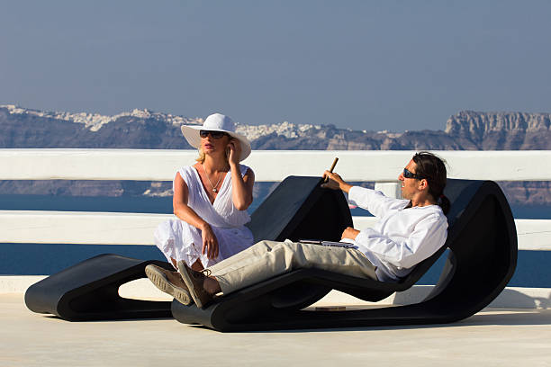 Couple "Elegant couple resting on the balcony in Santorini island,Greece" smoking women luxury cigar stock pictures, royalty-free photos & images