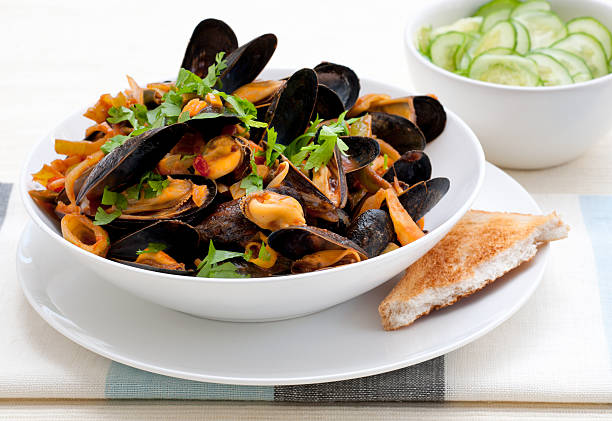istock bowl with cooked mussels and cucumber salad 184991619