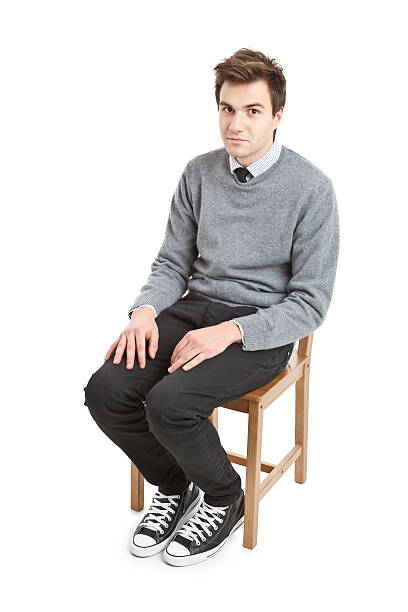 istock young handsome man in grey sweater sitting on chair 184991644