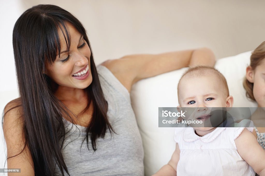Madre e figlia, seduto su un divano - Foto stock royalty-free di Abbigliamento casual