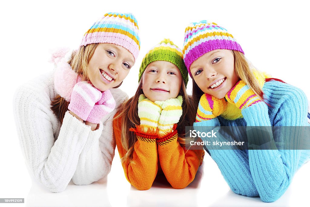 Tres niñas en colorido cardigans mirando a la cámara. - Foto de stock de Acostado libre de derechos