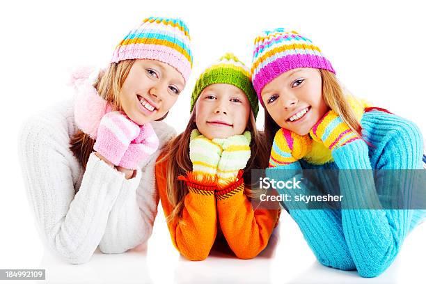 Tres Niñas En Colorido Cardigans Mirando A La Cámara Foto de stock y más banco de imágenes de Acostado