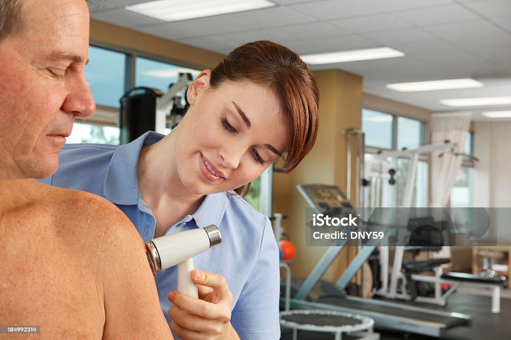 Fisioterapeuta administrar ultrassom em um homem do ombro. - Foto de stock de Manguito do Rotador royalty-free