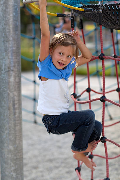 istock girl playing on rope at playground 184992349