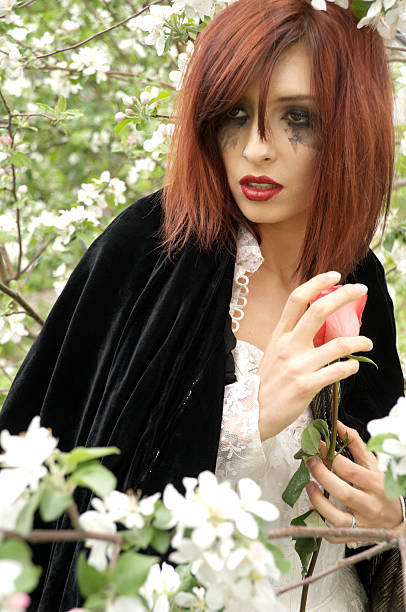 istock Jilted bride in black cloak among apple blossoms. 184992599