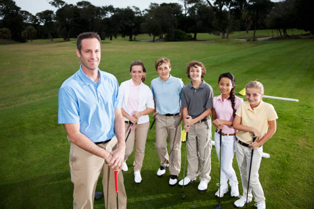 golf profesional con grupo de niños en el campo de práctica de golf - sc0529 fotografías e imágenes de stock