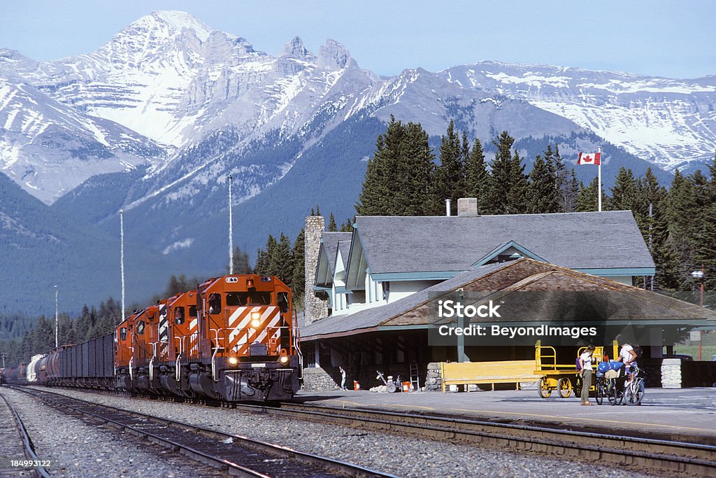 Rojo, las locomotoras hauling transporte de las montañas coronadas de nieve - Foto de stock de Columbia Británica libre de derechos