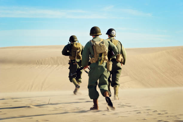 WWII Soldiers and Medic On Patrol In The Desert stock photo