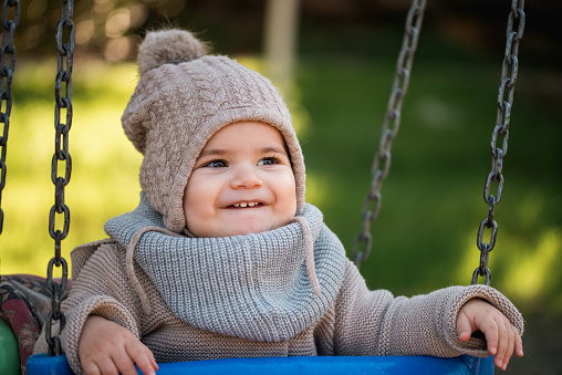 portrait of happy baby swinging on swing