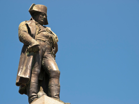 A large lifelike statue of Napoleon in Ajaccio by blue sky.