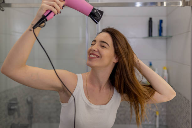 istock Young Woman Drying Her Hair with a Blow Dryer 1849938607