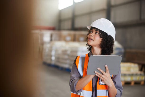 istock Female engineer working with a tablet in a large shipping warehouse 1849938611