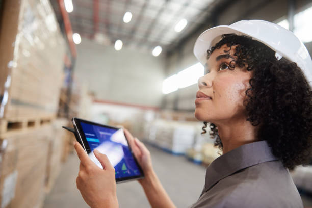istock Female engineer using an app on a tablet to track warehouse shipments 1849946063