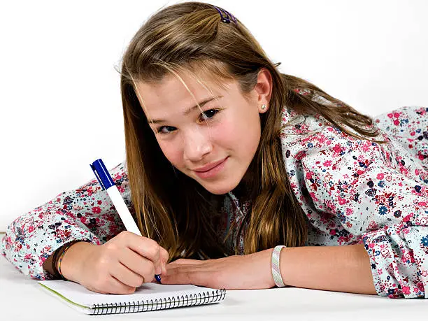 A teenager girl writing in a spiral notebook
